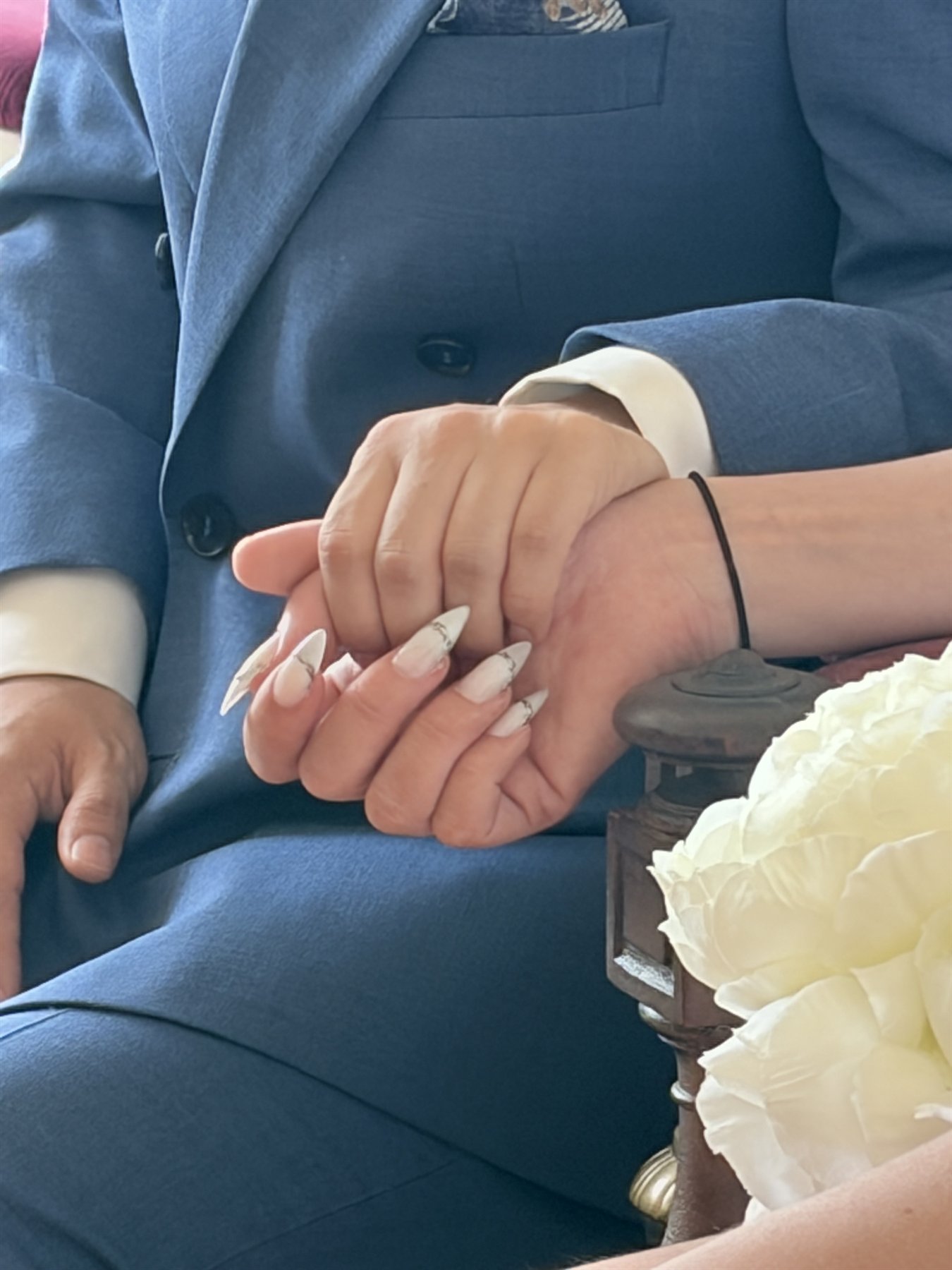 A close detail of wedding hands and flowers